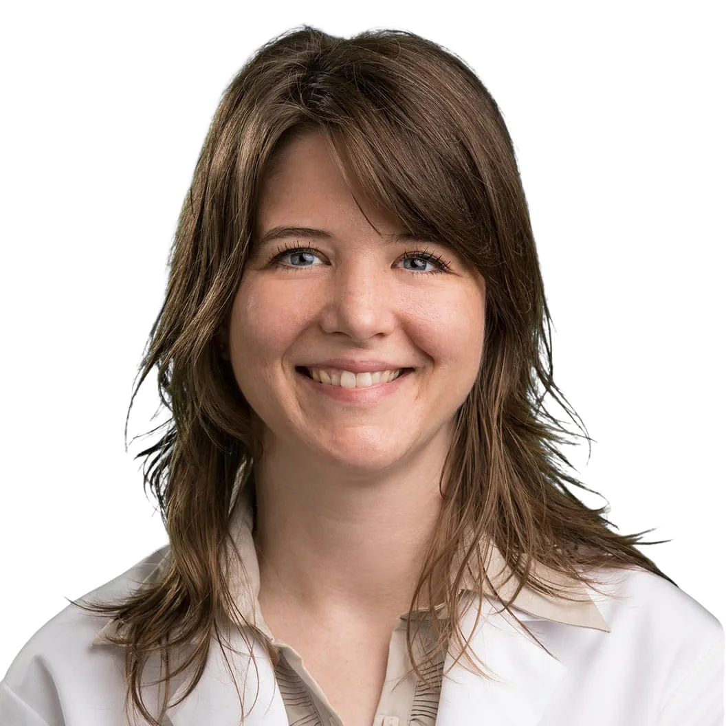 Portrait Of Mature Male Doctor Wearing White Coat Standing In Hospital Corridor