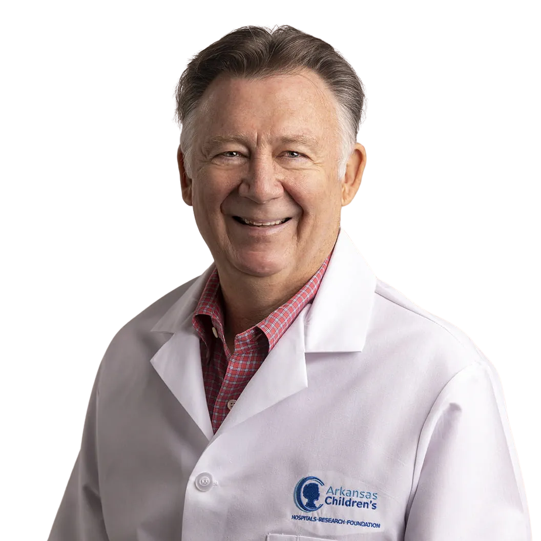Portrait Of Mature Male Doctor Wearing White Coat Standing In Hospital Corridor