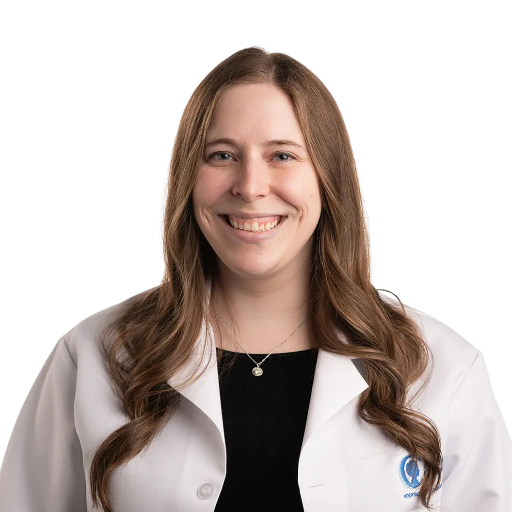 Portrait Of Mature Male Doctor Wearing White Coat Standing In Hospital Corridor