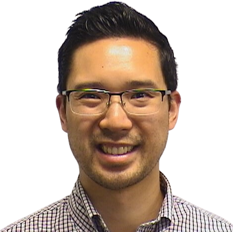 Portrait Of Mature Male Doctor Wearing White Coat Standing In Hospital Corridor