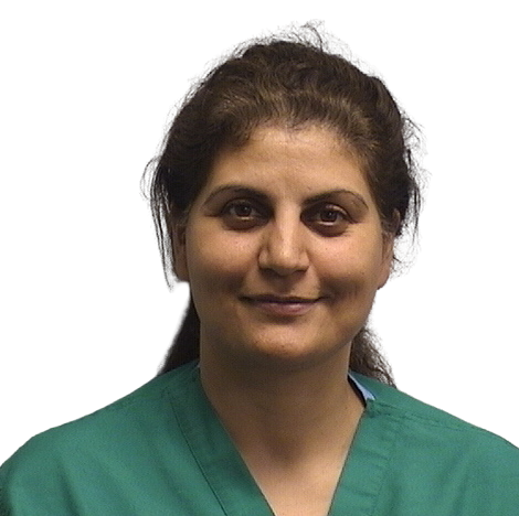 Portrait Of Mature Male Doctor Wearing White Coat Standing In Hospital Corridor