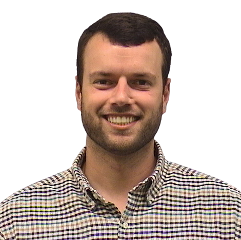 Portrait Of Mature Male Doctor Wearing White Coat Standing In Hospital Corridor