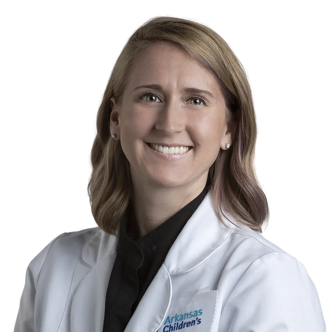 Portrait Of Mature Male Doctor Wearing White Coat Standing In Hospital Corridor