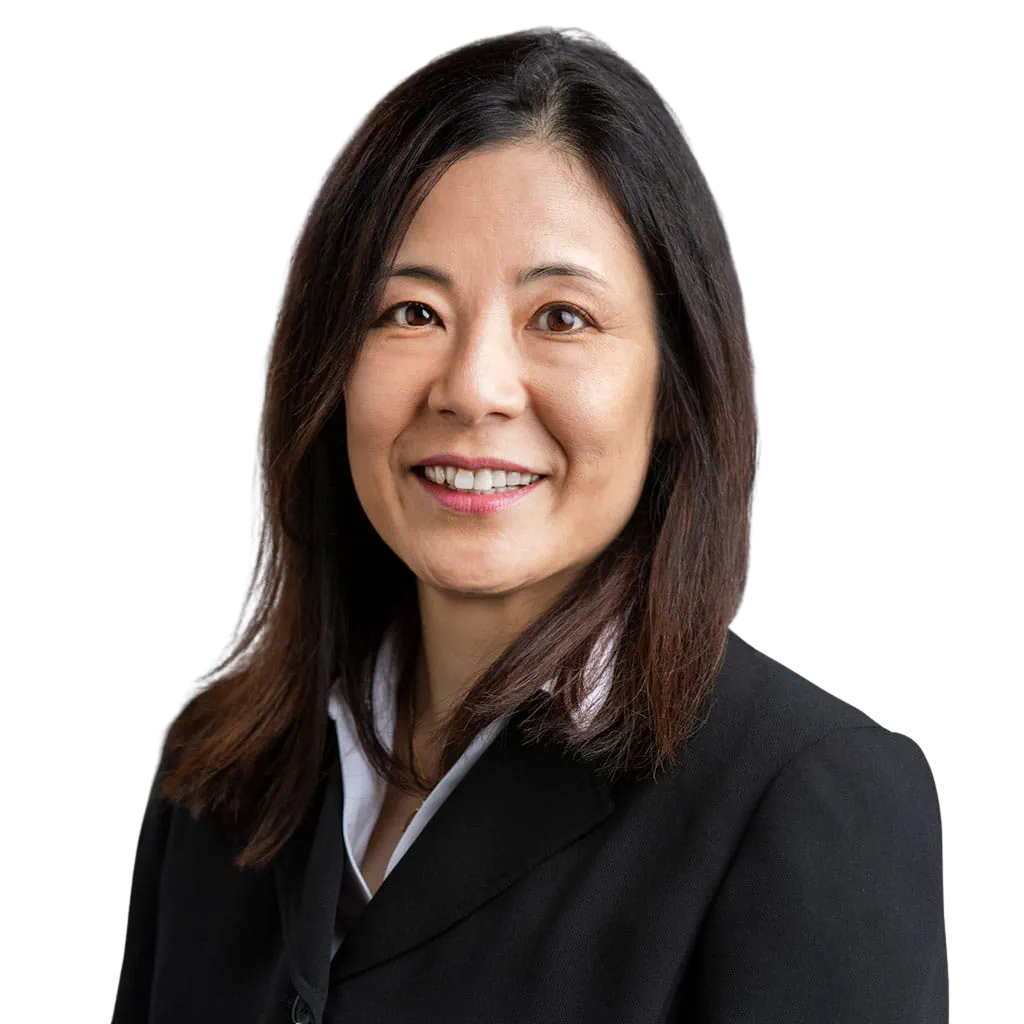 Portrait Of Mature Male Doctor Wearing White Coat Standing In Hospital Corridor