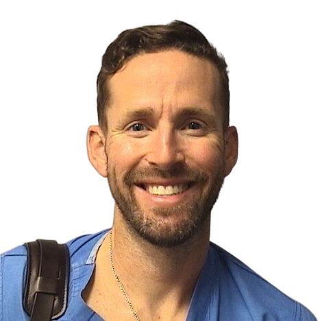 Portrait Of Mature Male Doctor Wearing White Coat Standing In Hospital Corridor