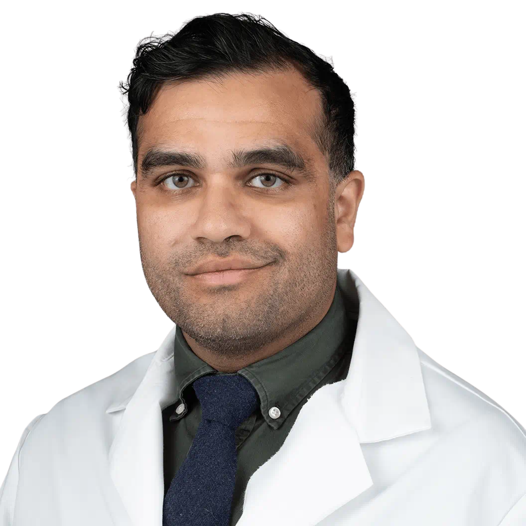 Retrato de médico masculino maduro con bata blanca de pie en el pasillo del hospital