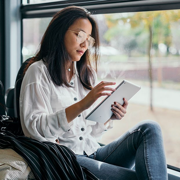 lady sitting on bus holding tablet