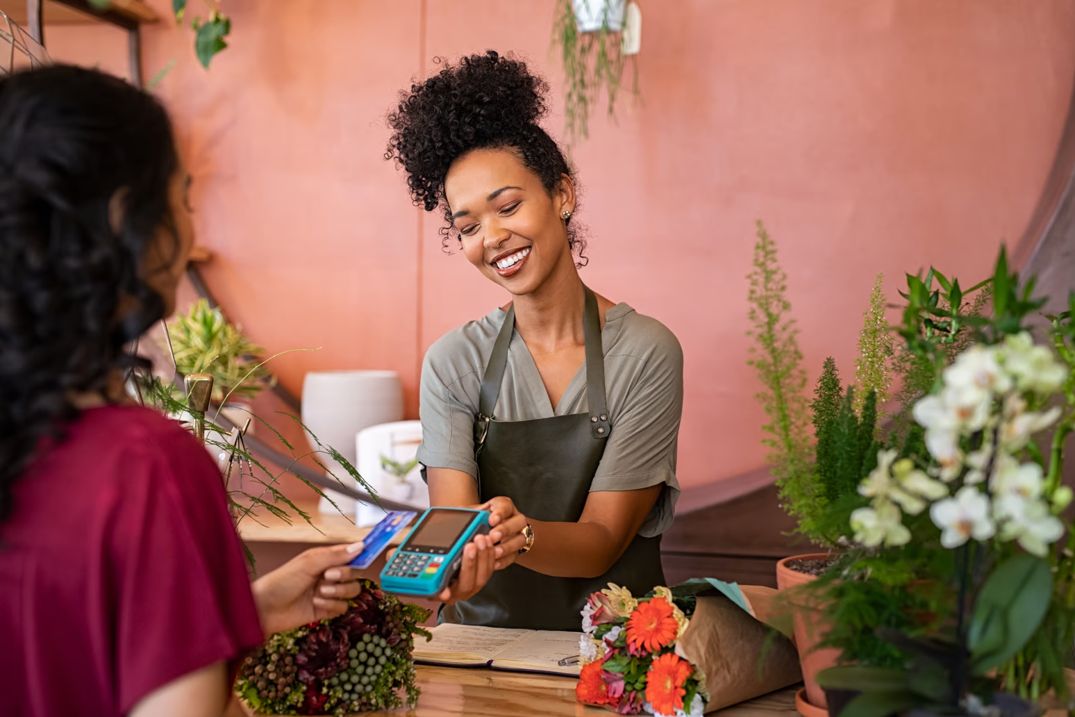 employee at flower shop holding out card reader to customer