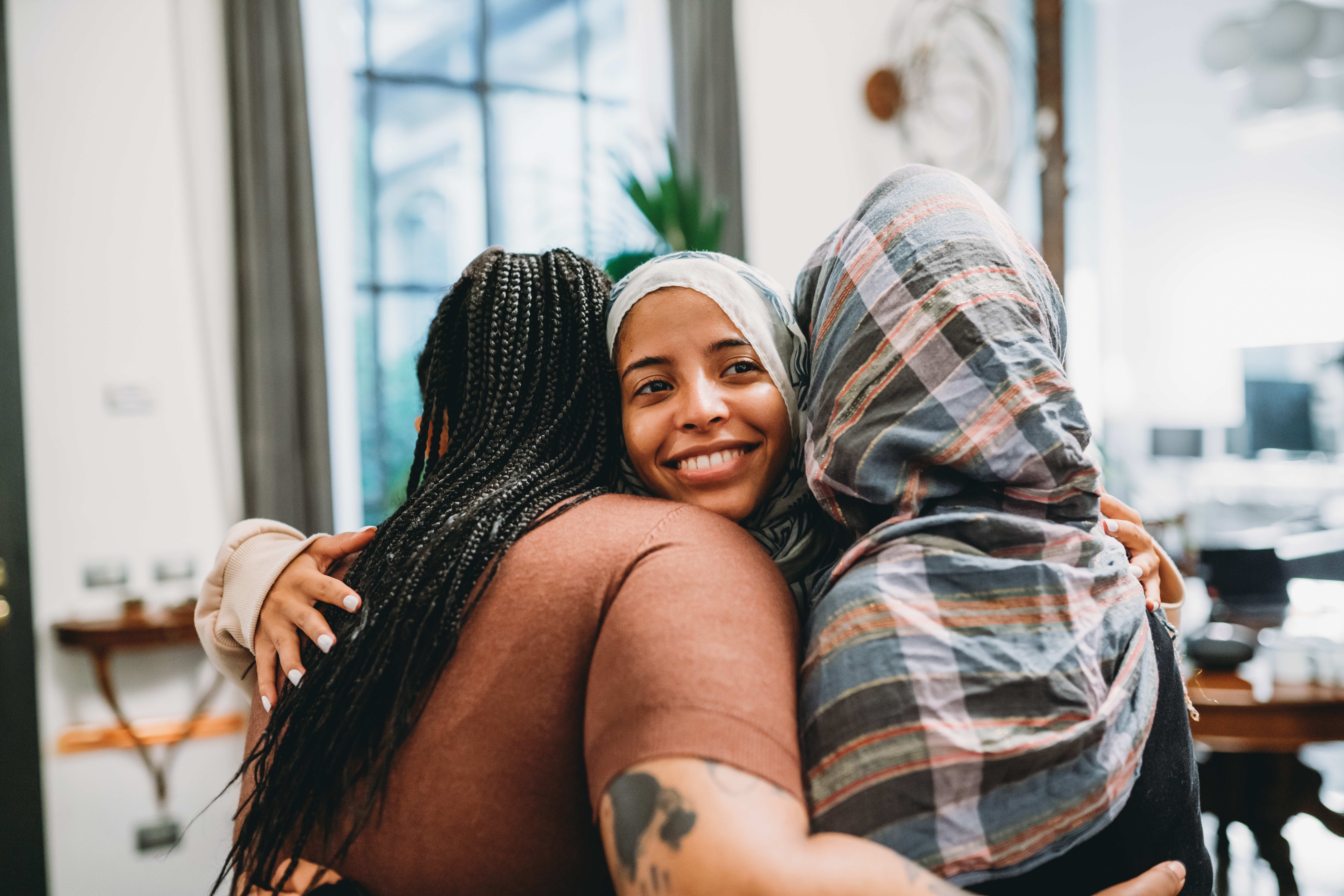 Diverse group of female work colleagues hugging