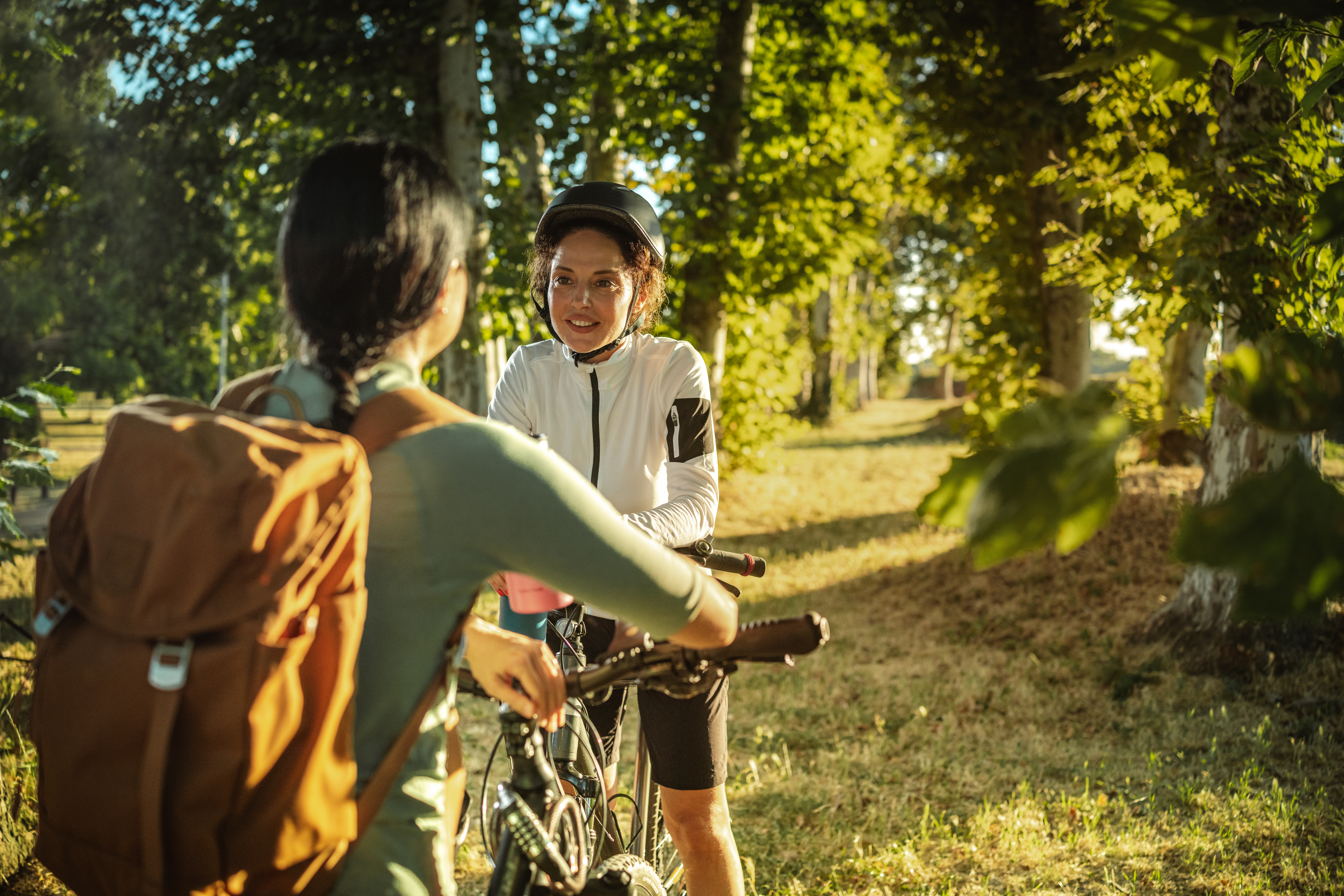 Two women stopping for a chat while on a bike ride through woodland