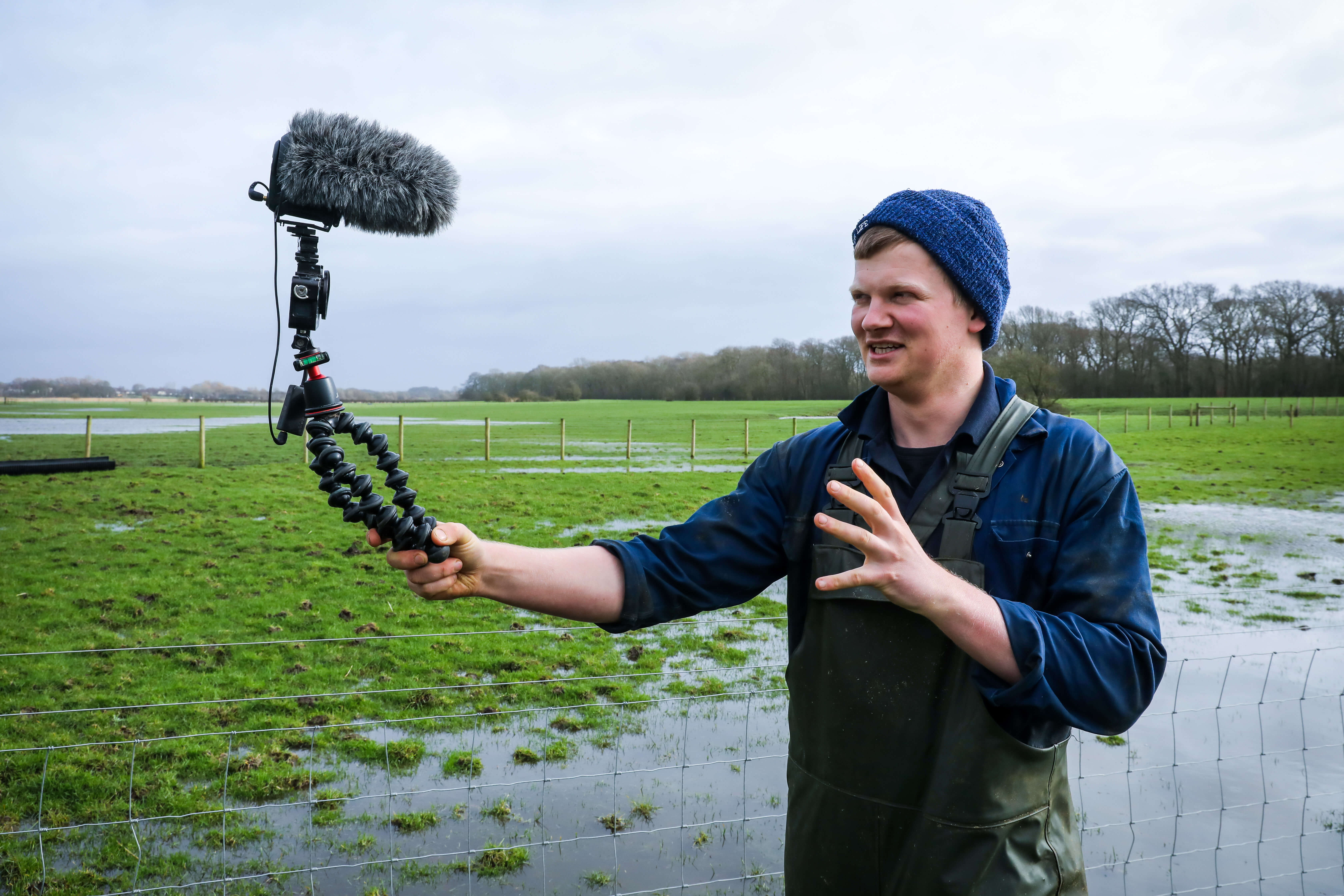 Tom Pemberton on his farm in Lytham St Annes, Lancashire vlogging to camera in a wet field