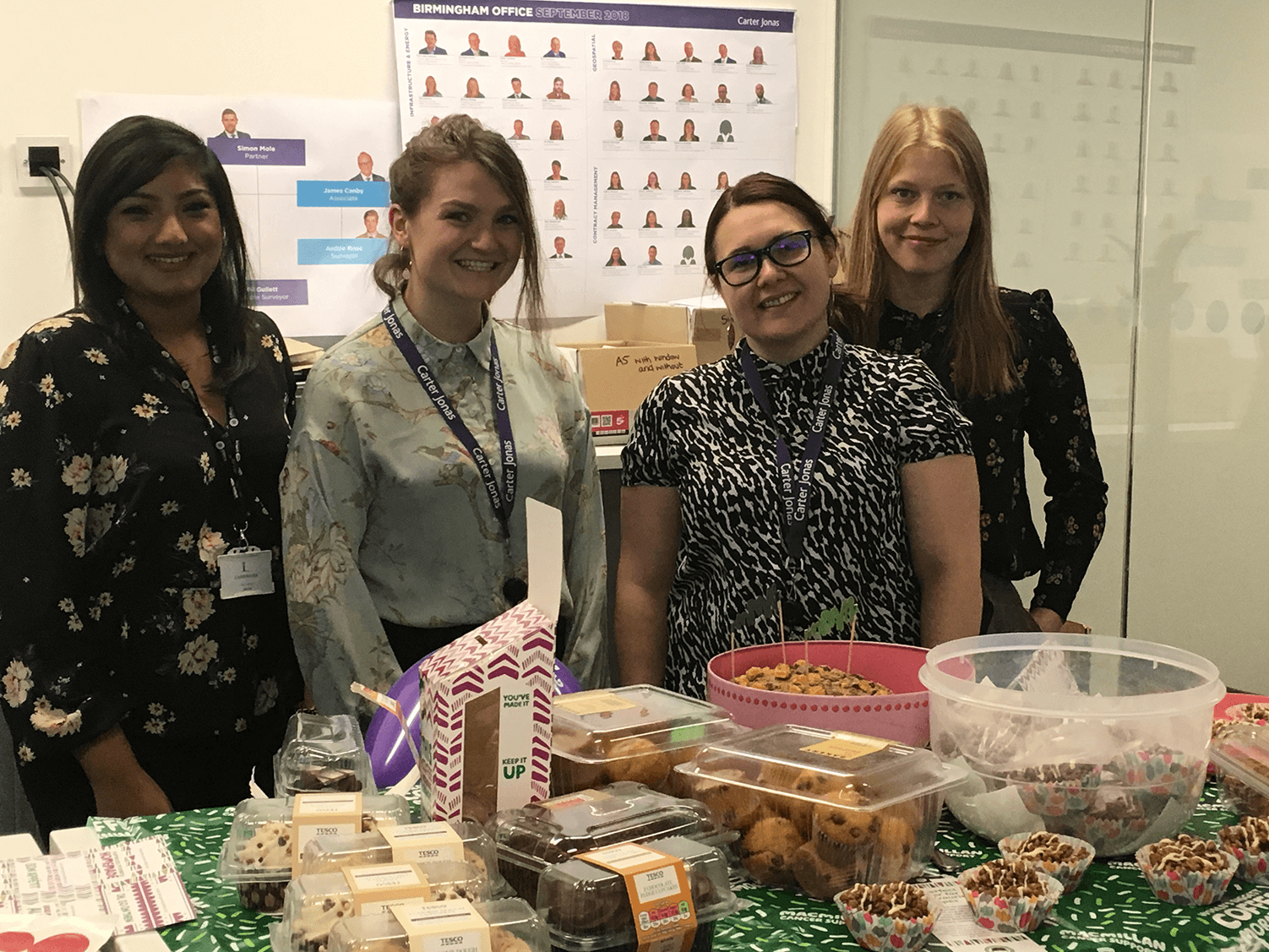 photograph of four carter jonas members at bake sale
