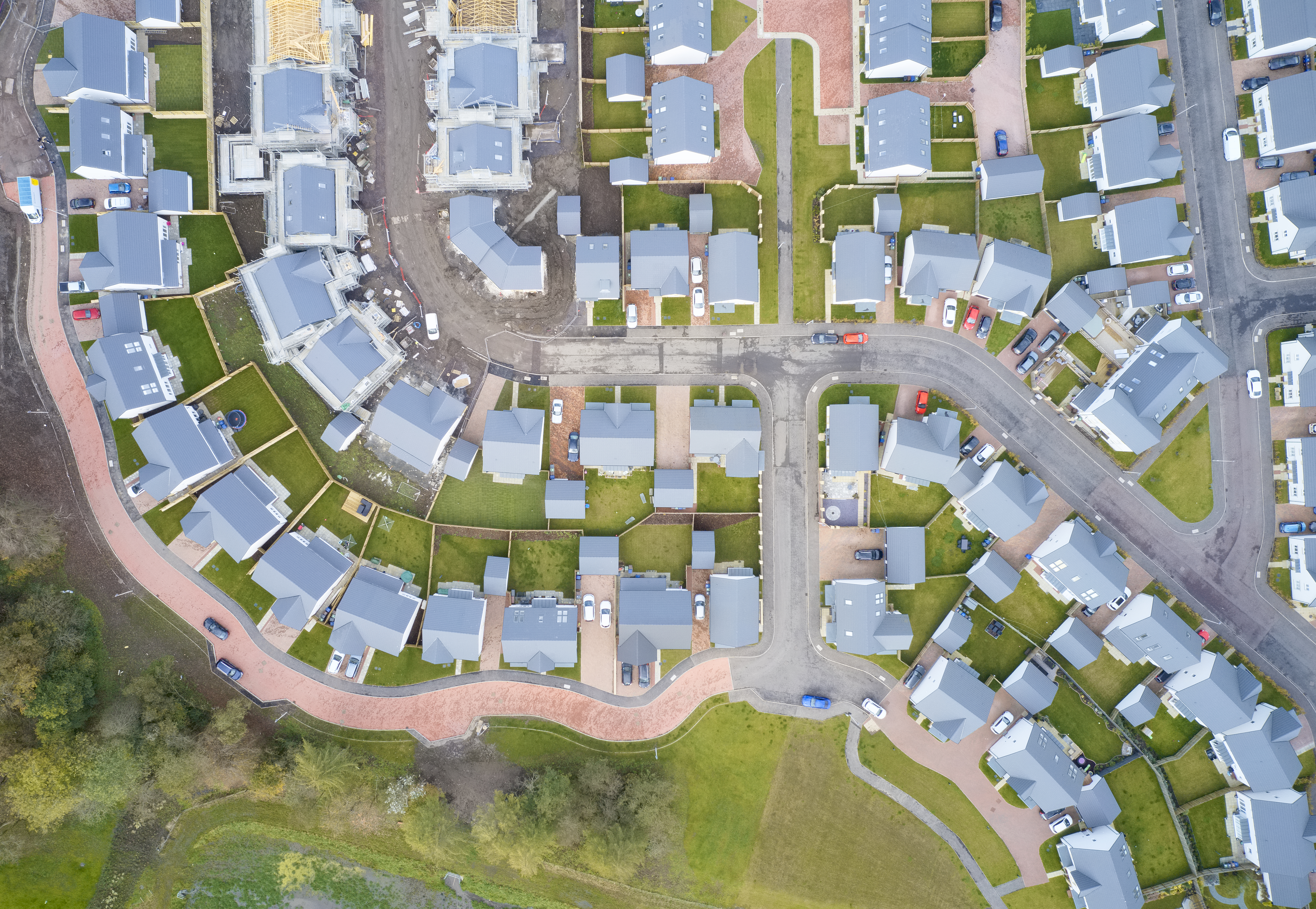 Suburban houses in row aerial view in summer illuminating gardens uk