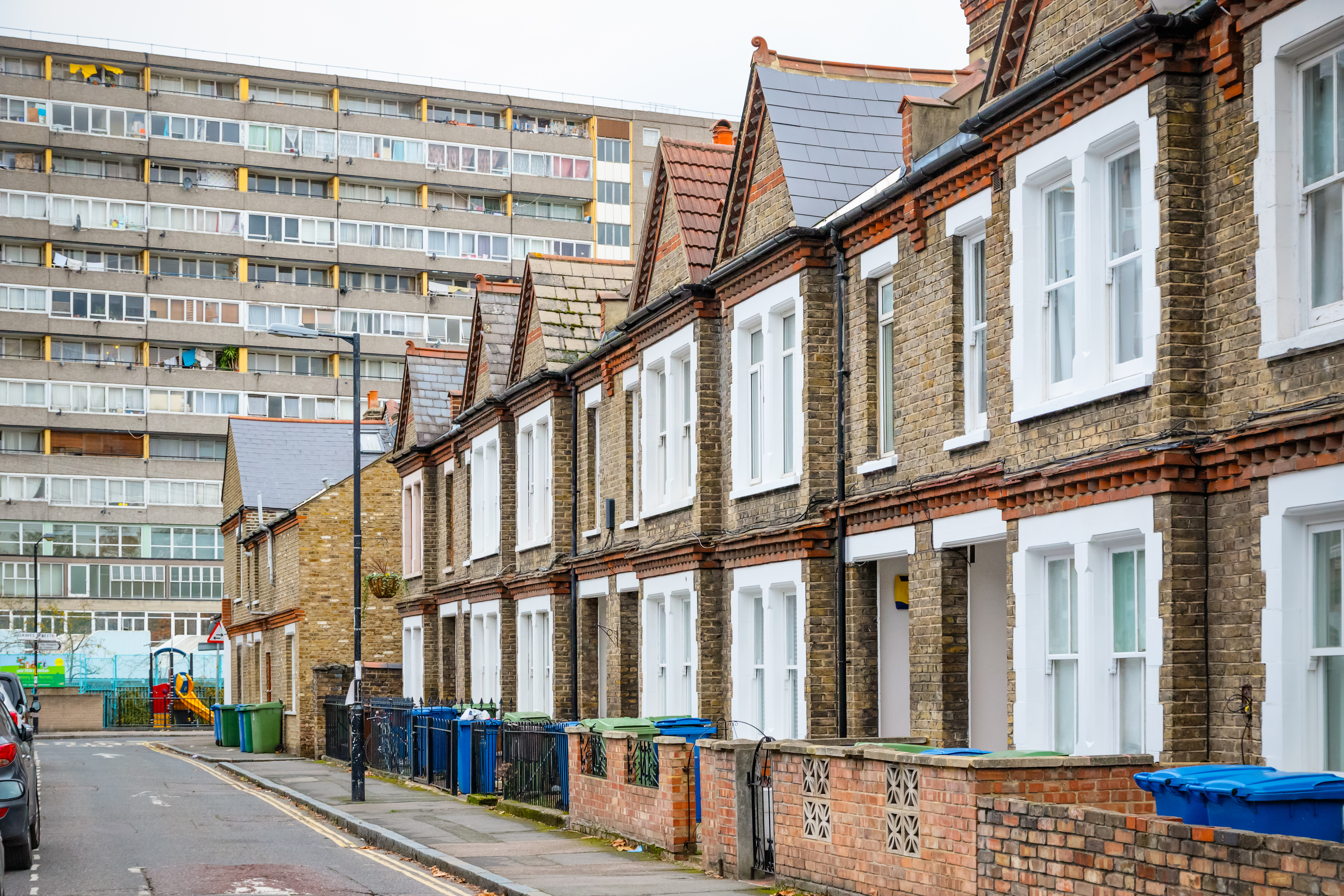 Traditional English terraced houses with huge council block in the background in south east London
