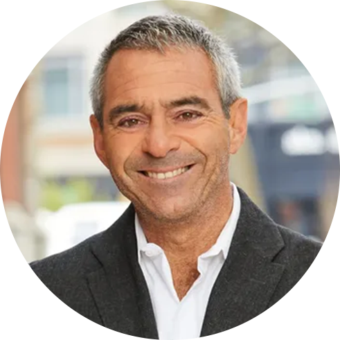 Danny Davis wearing a white shirt and dark blazer standing outdoors.