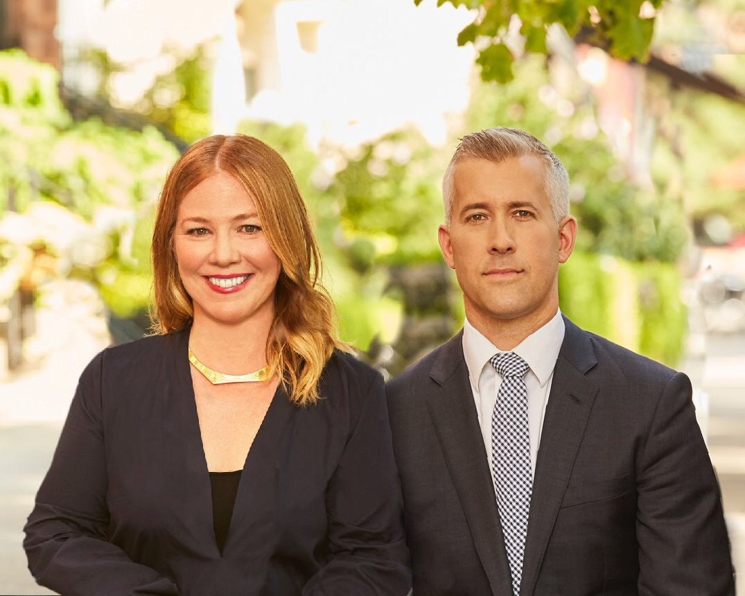 Person with long, light brown hair shown in a circular frame and a blurred green and yellow background.
