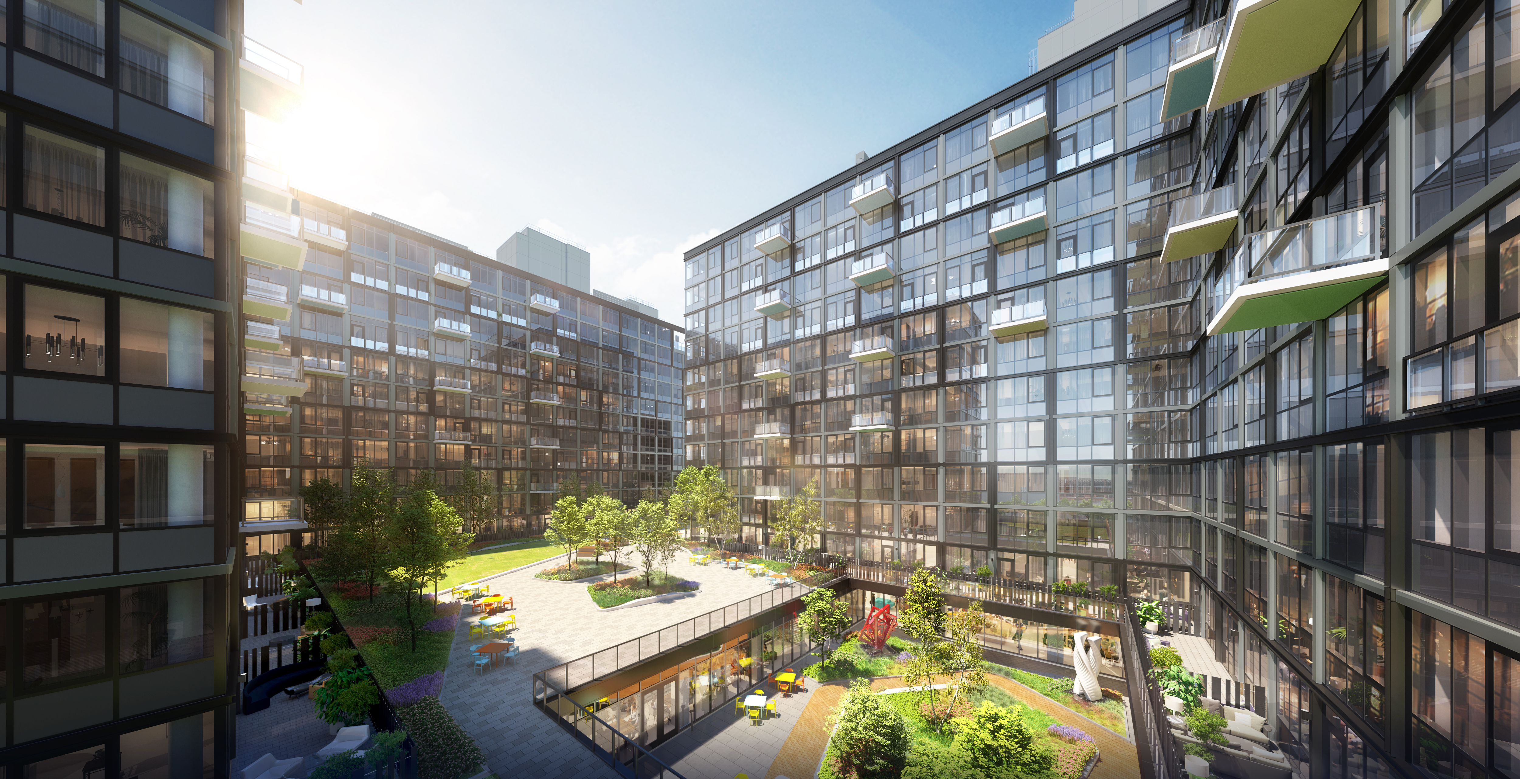 A modern apartment complex with large glass windows surrounding a central courtyard filled with greenery, trees, and outdoor seating areas under a bright blue sky.