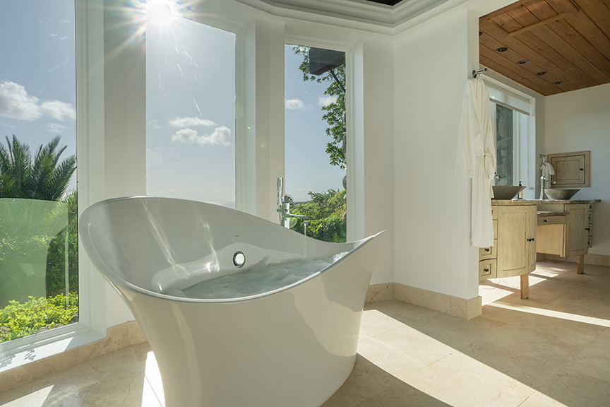 Modern bathroom with a freestanding tub, large windows, and a wooden vanity.