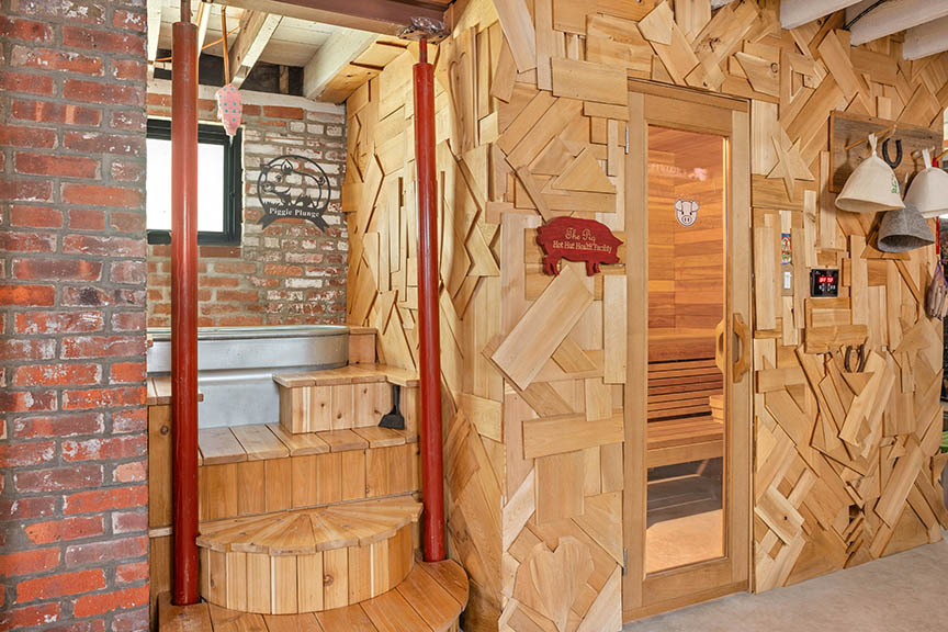 Interior with sauna, cold plung, brick walls, and wood paneling.