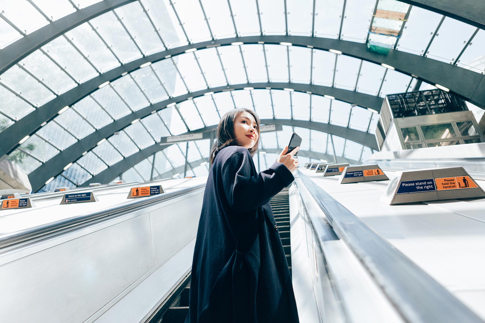 Woman using mobile device on elevator