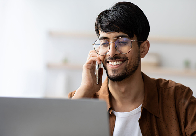 Indian man working from home and using phone