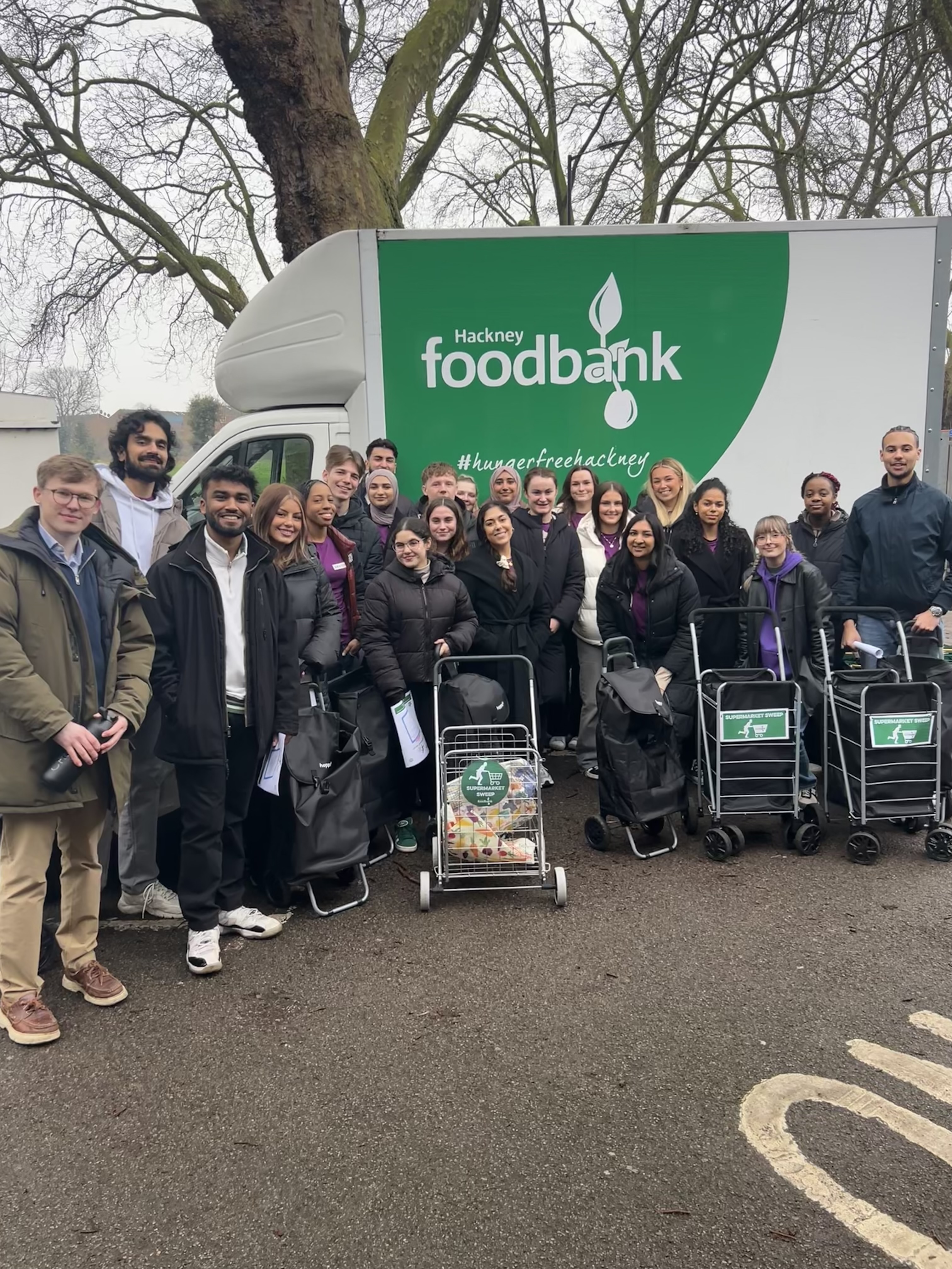 London volunteers at London foodbank, standing in front of a delivery van