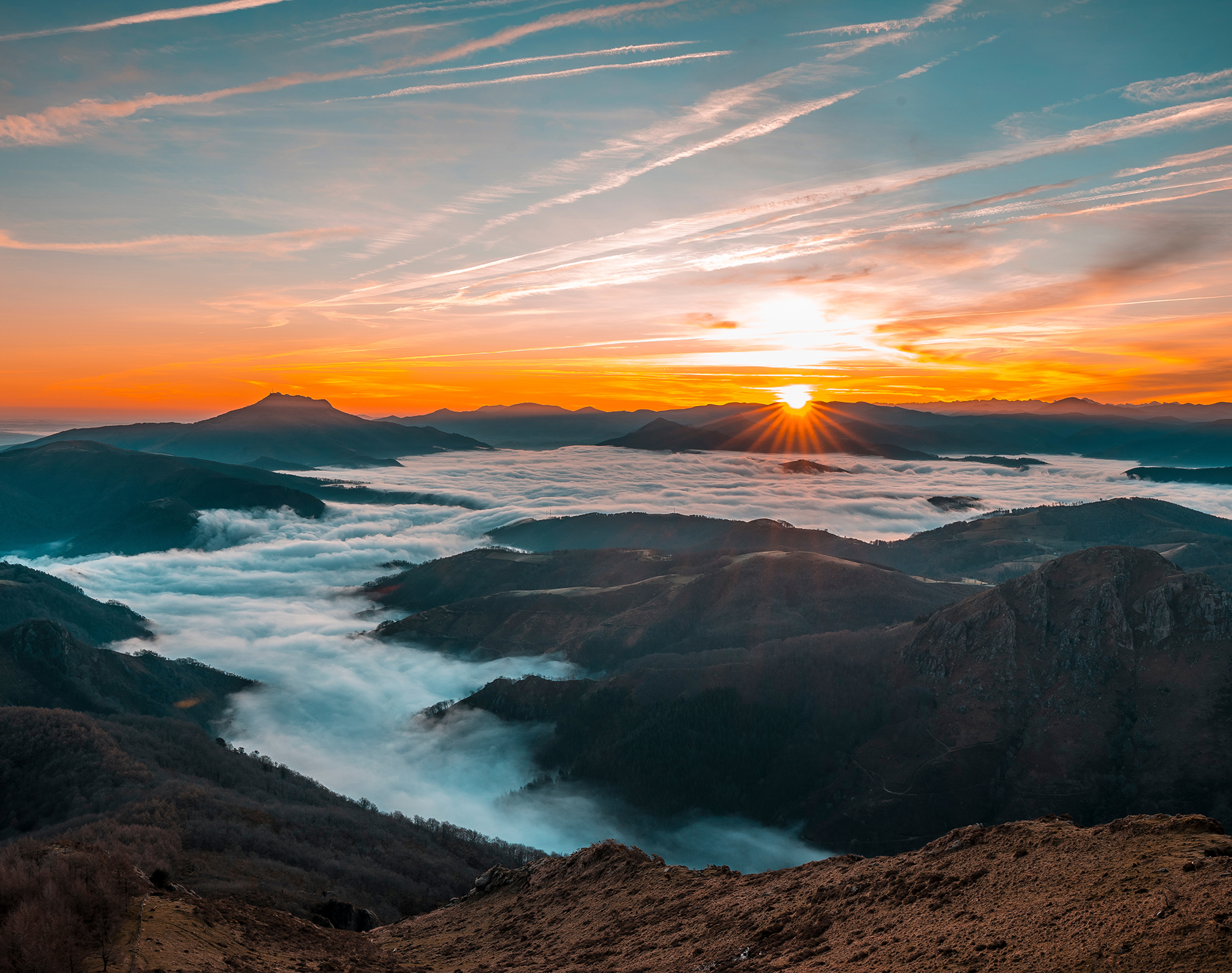 Sunrise from a mountain top with the clouds below