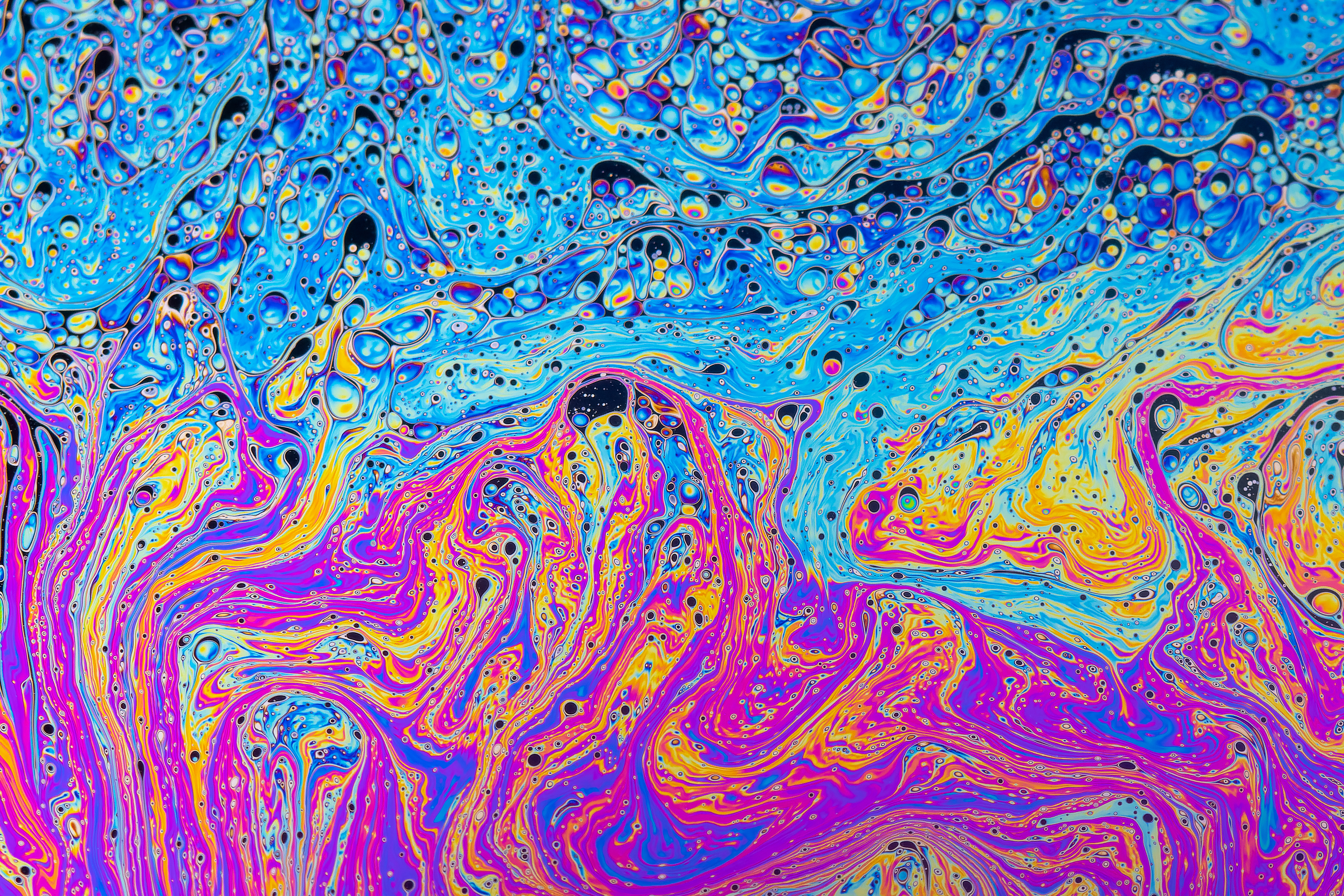 Fluid soap bubble in motion with psychedelic colourful abstract patterns