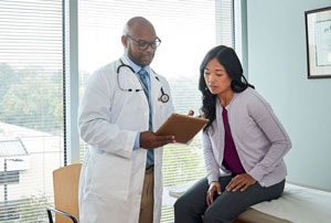An image of a doctor reviewing results with a female patient in an exam room