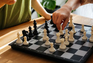 A close up shot of two children playing chess together