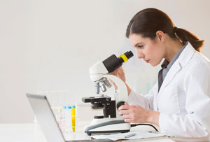 A scientist looking in a microscope in a lab