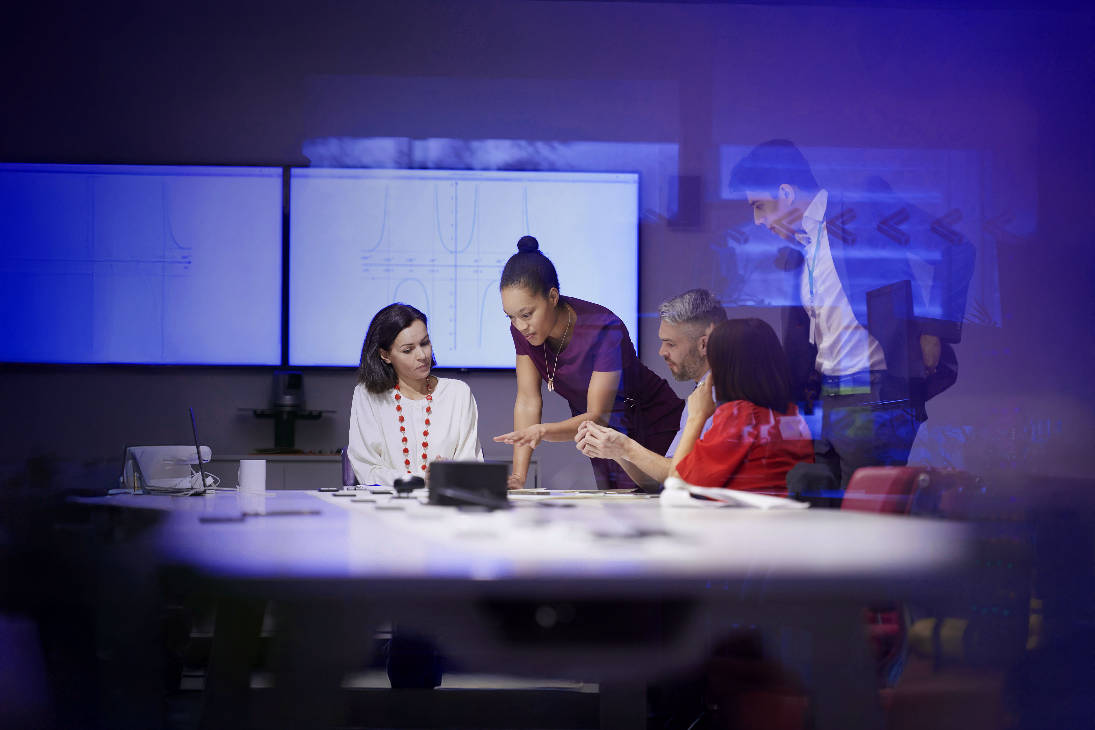 Group of five people inside a conference room and having a collaboration session