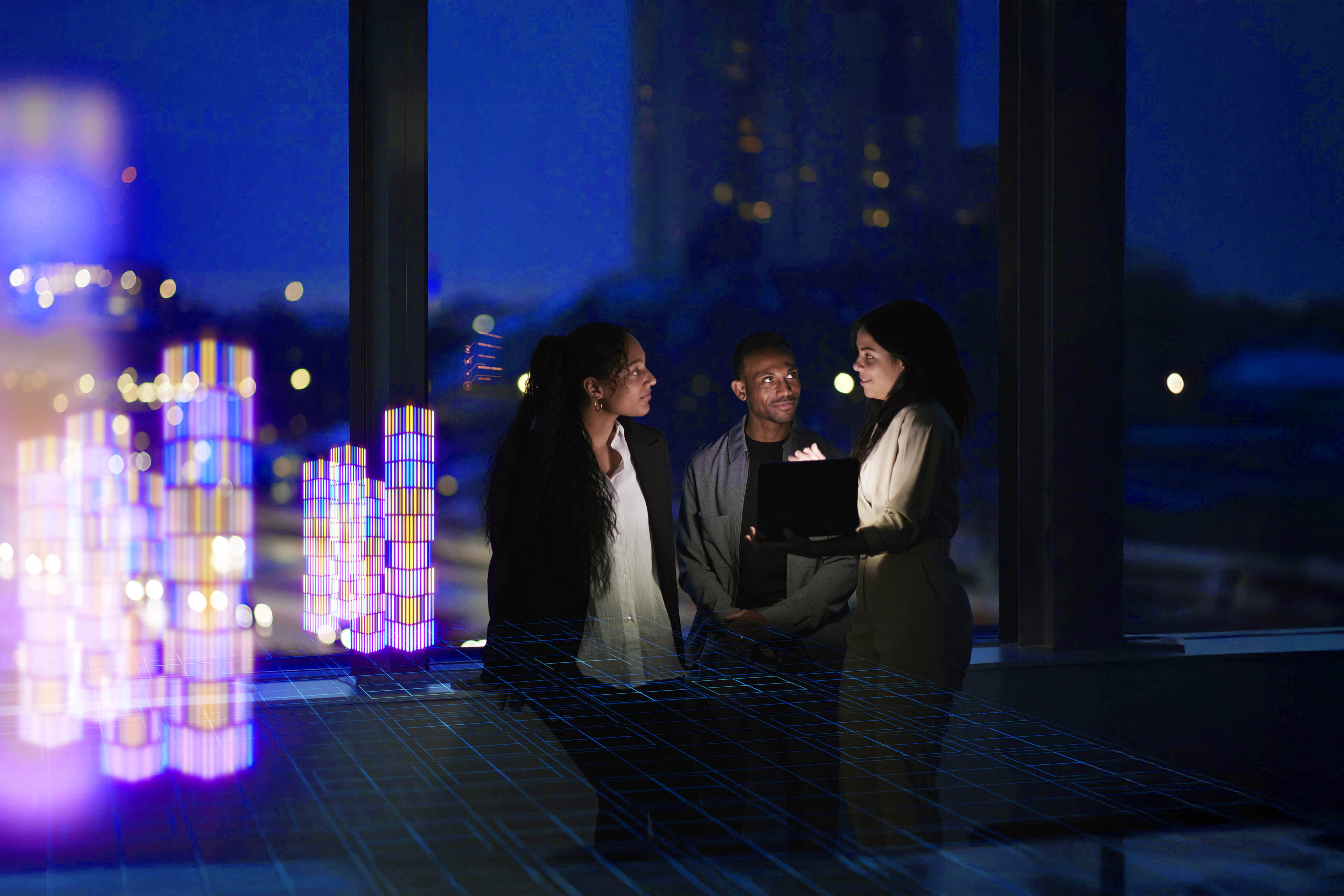An image of three business professionals huddled in a conversation with the person on the right holding a tablet 