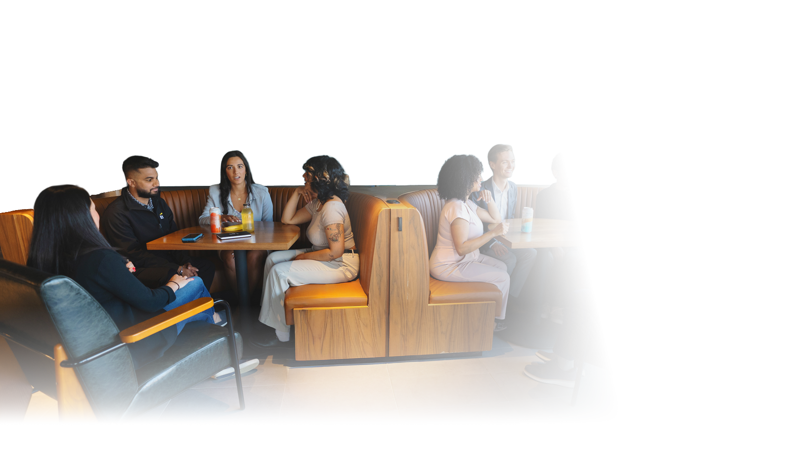 group of professionals sitting on a banquette and having a discussion over iced tea and soft drinks