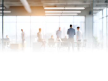 Image looking towards a group of professionals inside a conference room in a meeting