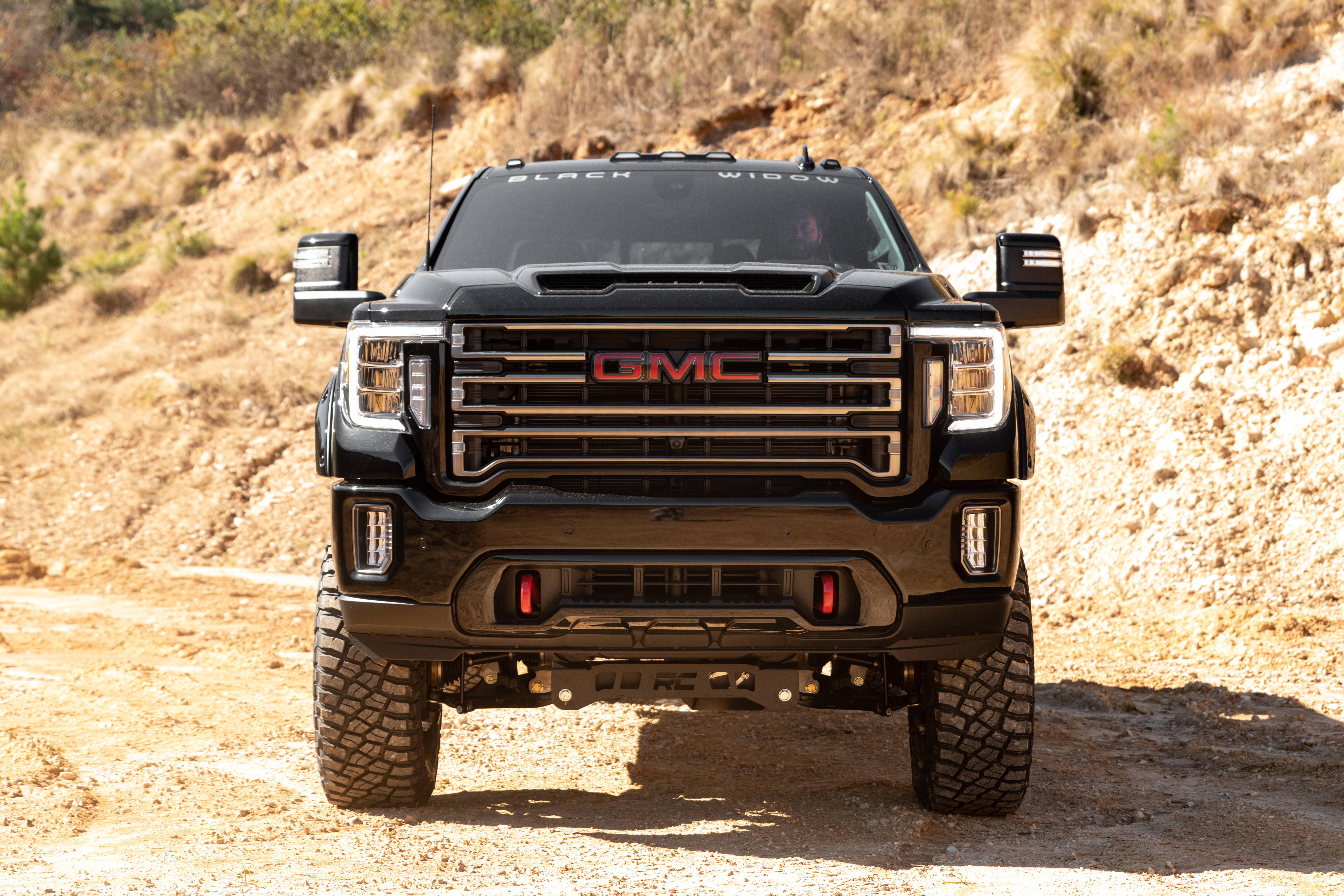 The Black Widow Truck windshield banner and 50-State legal front window tint on a GMC Sierra Lifted Truck