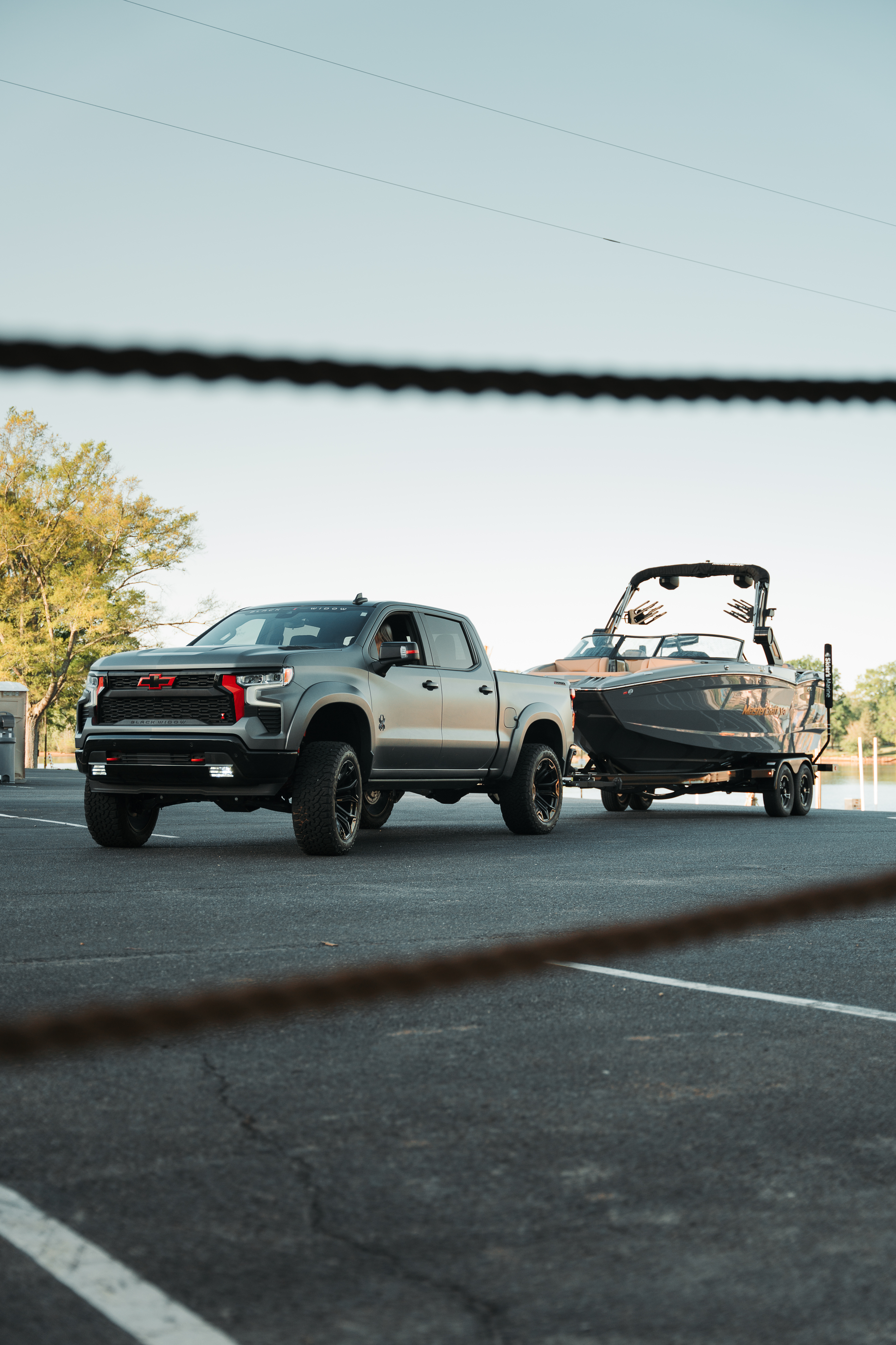 Chevrolet Silverado 1500 grill on a Black Widow Lifted Truck red accents and red tow hooks