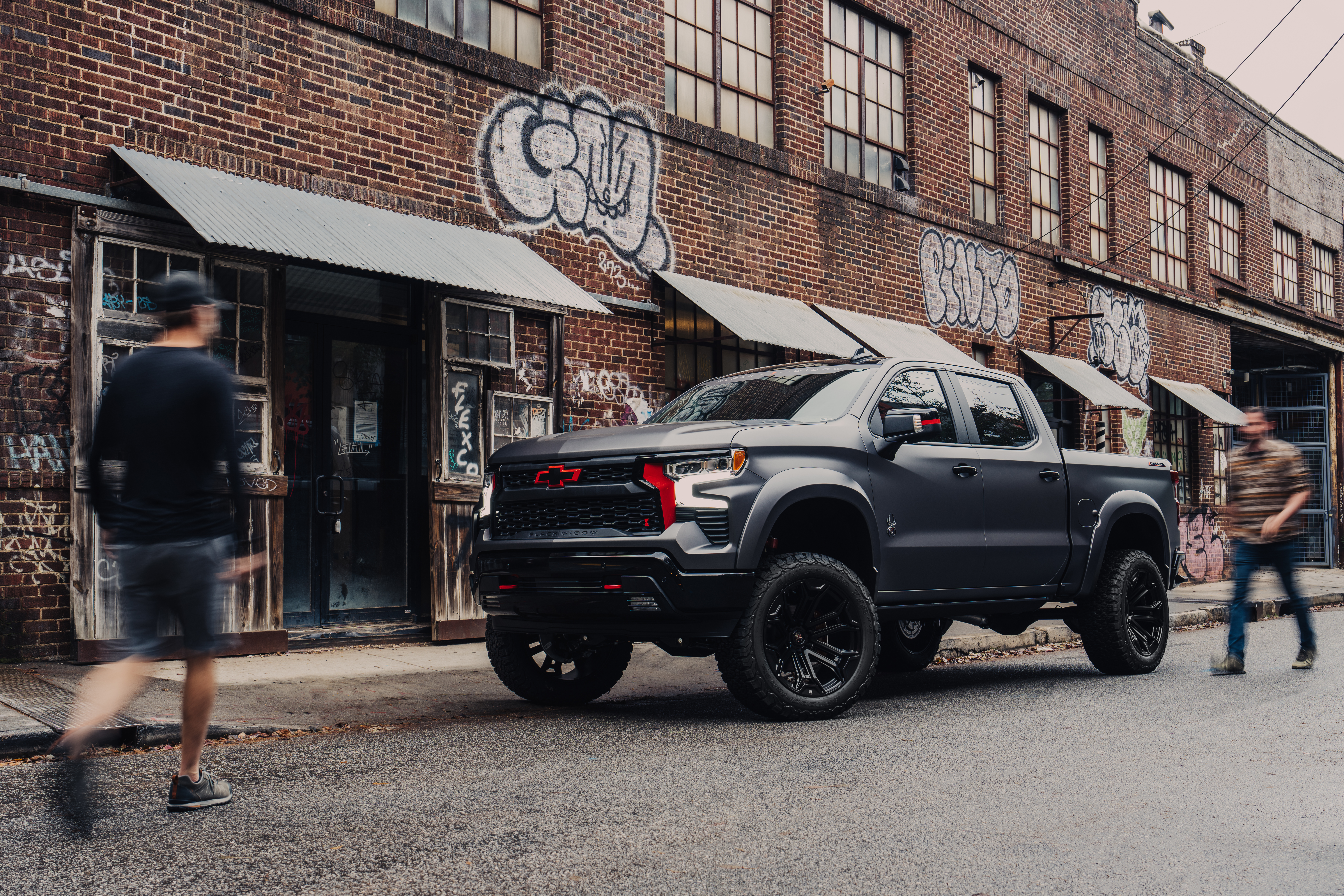 Matte black lifted truck. Black widow chevrolet silverado 1500 in the city.