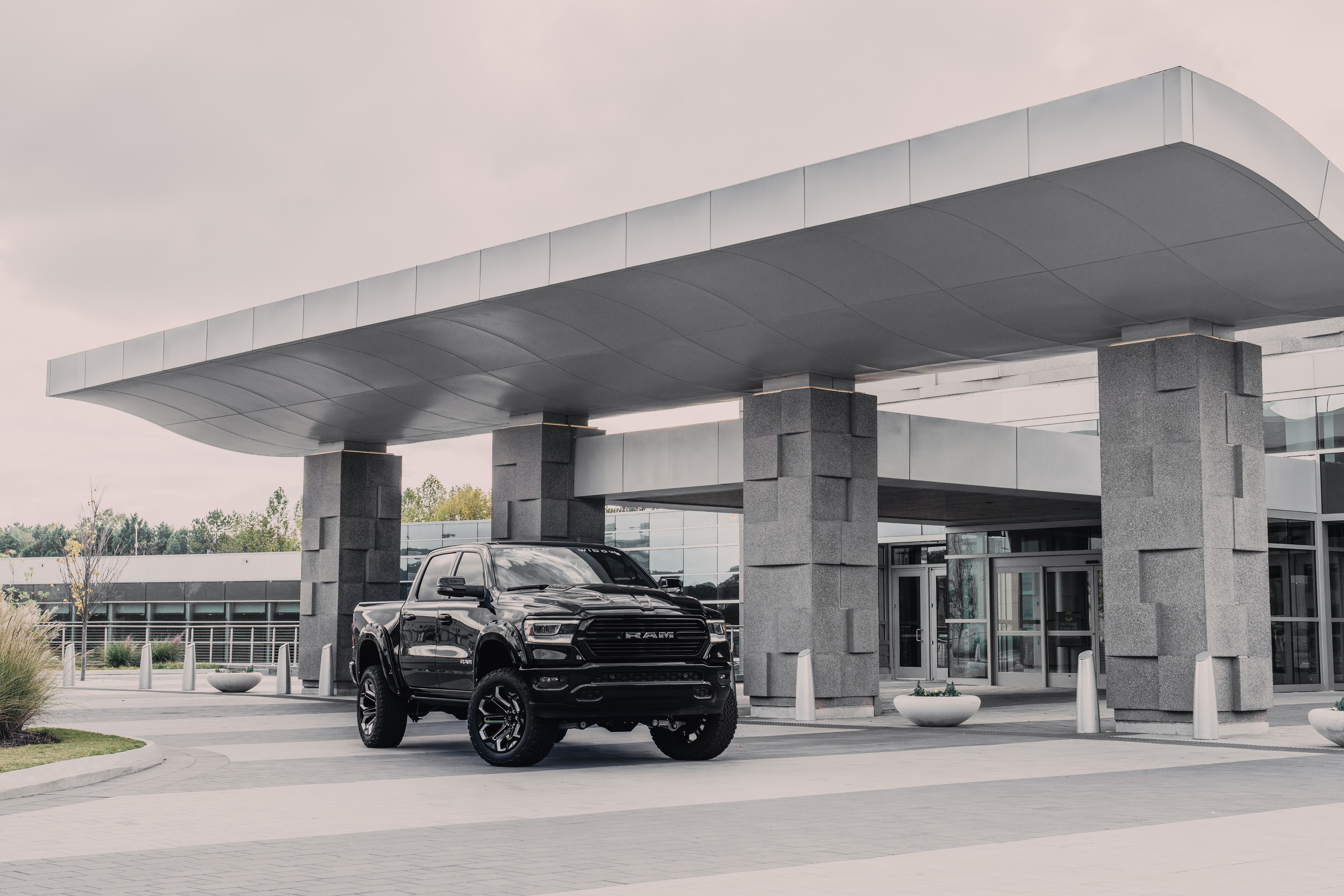 Shiny black ram 2500 lifted black widow truck parked outside of a  hotel 