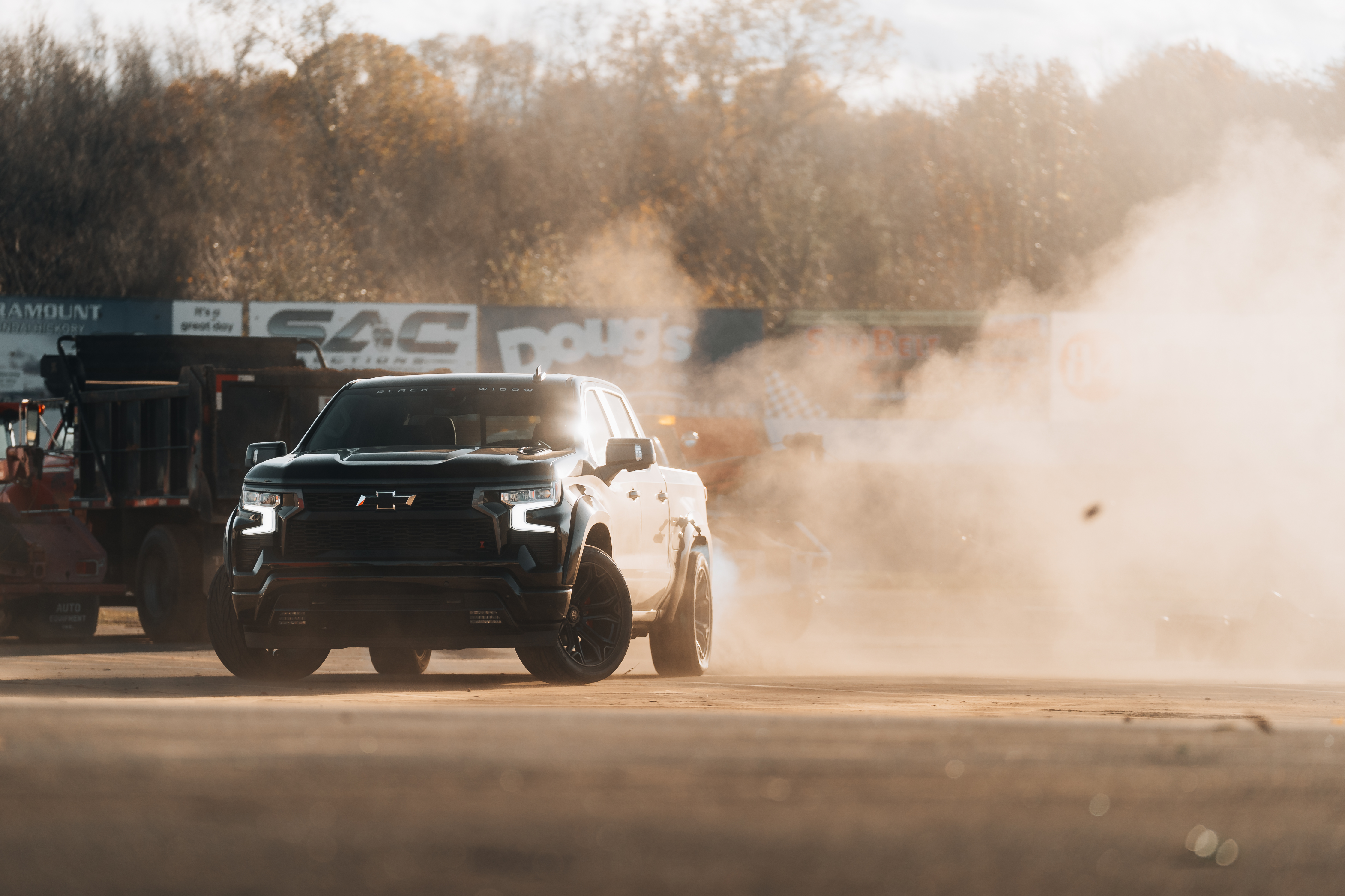Woman enjoying the view of a lifted silverado Black Widow truck.