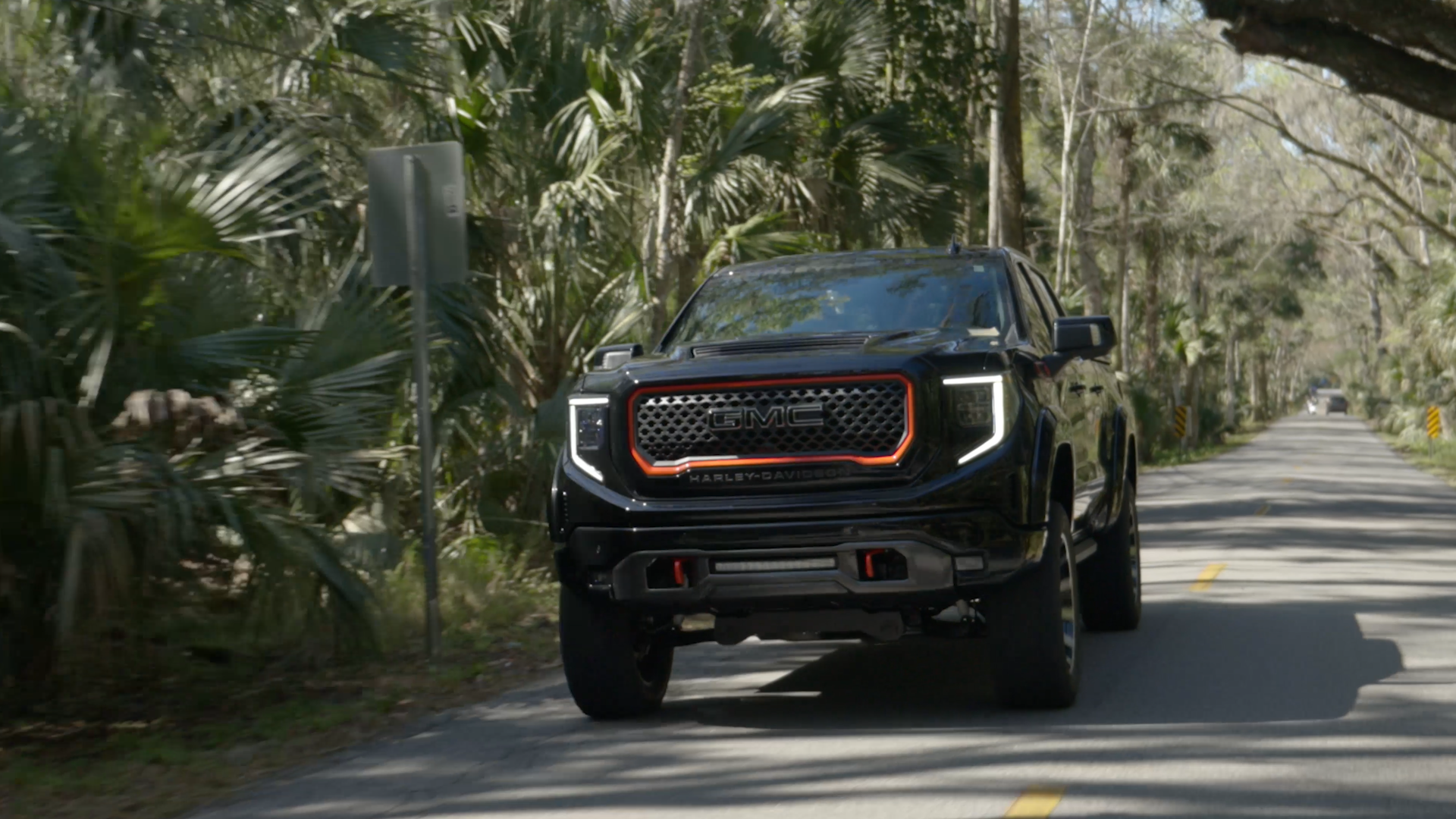 black gmc 1500 lifted Harley-Davidson truck driving in the florida everglades