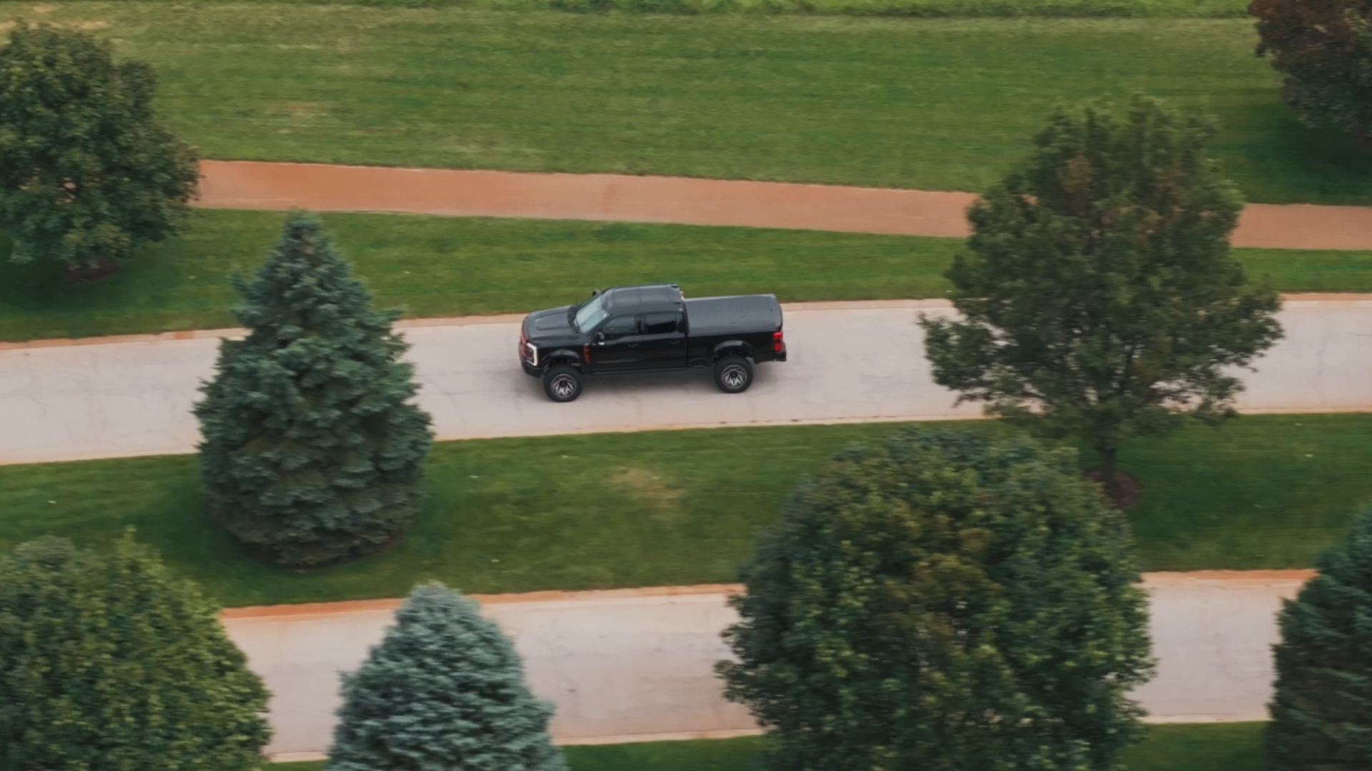 black lifted Harley-Davidson truck driving on road viewed from above