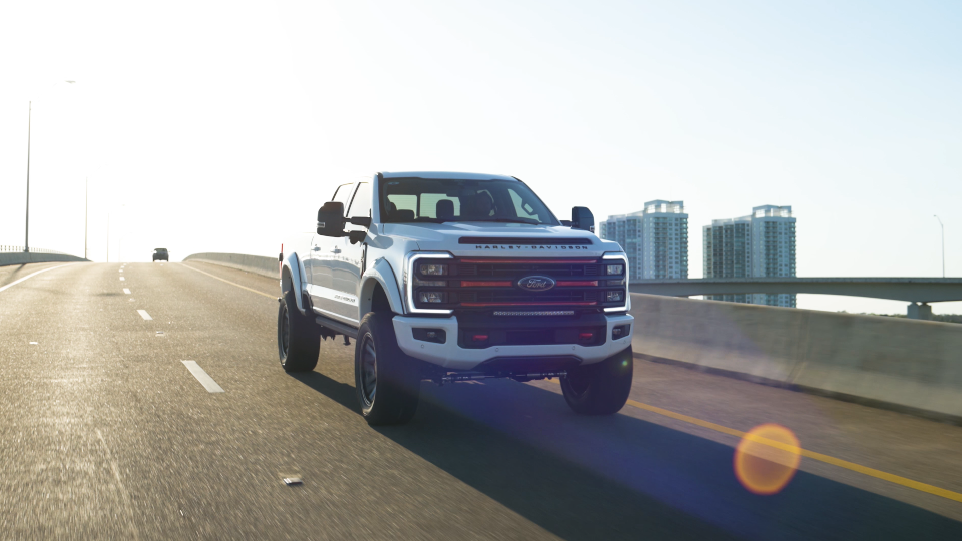 white lifted superduty Harley-Davidson truck driving on a bridge