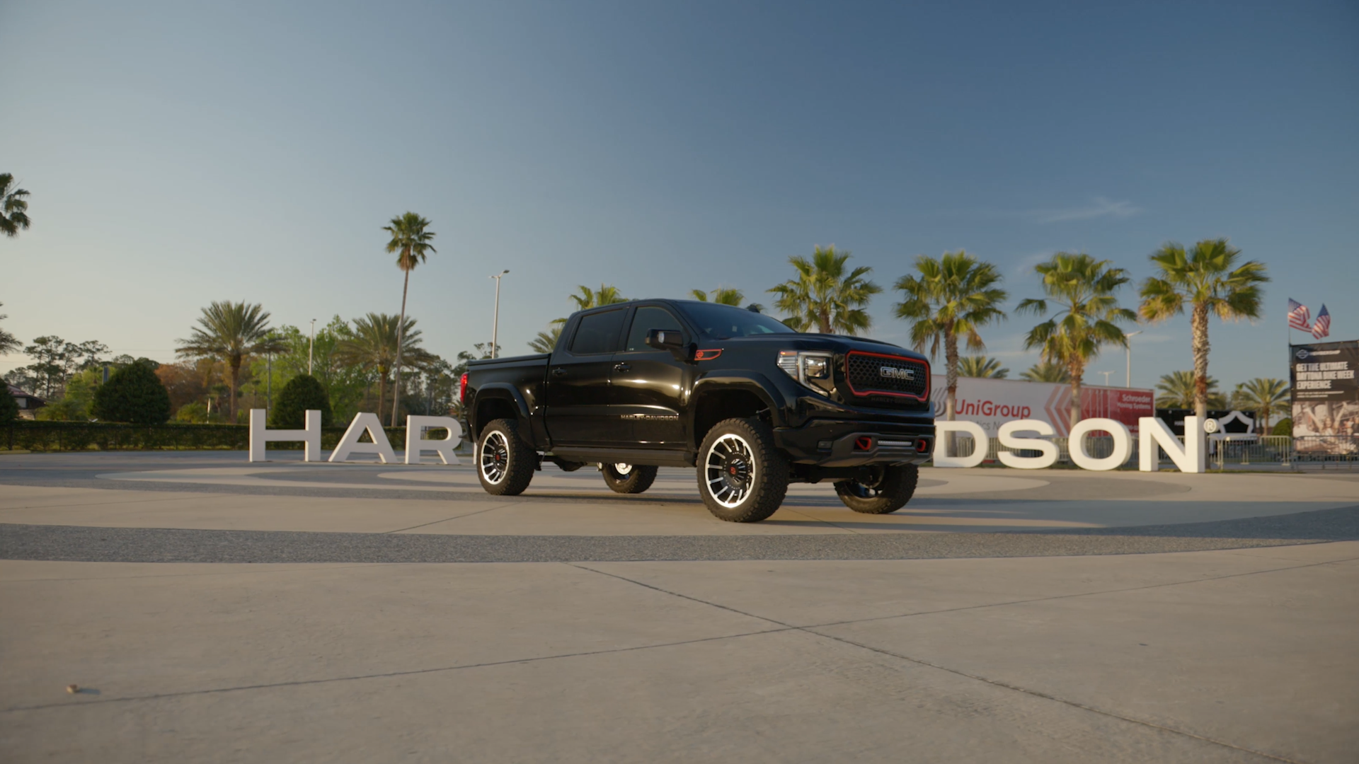black lifted Harley-Davidson gmc 1500 in front of the Harley-Davidson sign