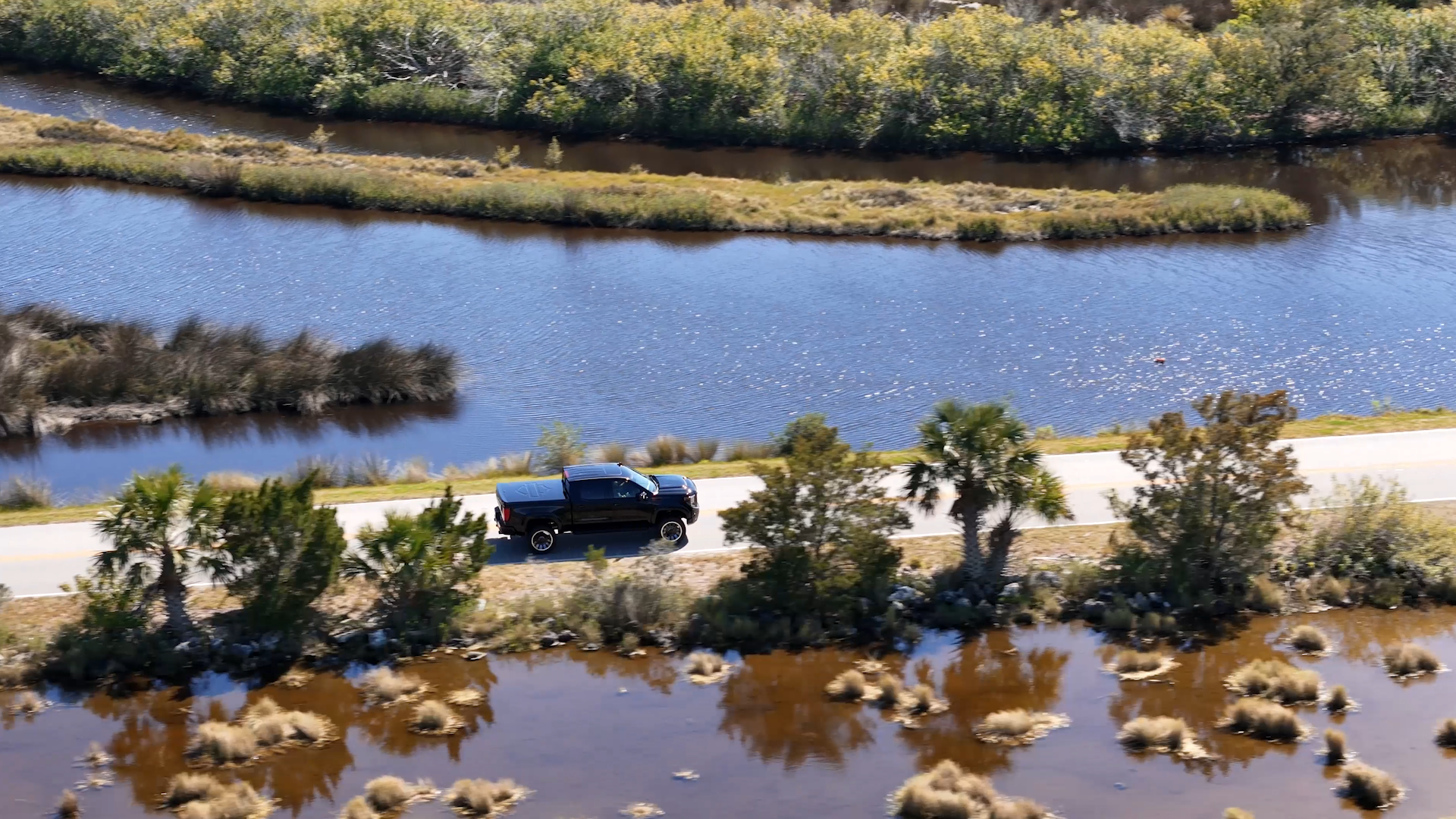black Harley-Davidson lifted truck driving through the florida everglades