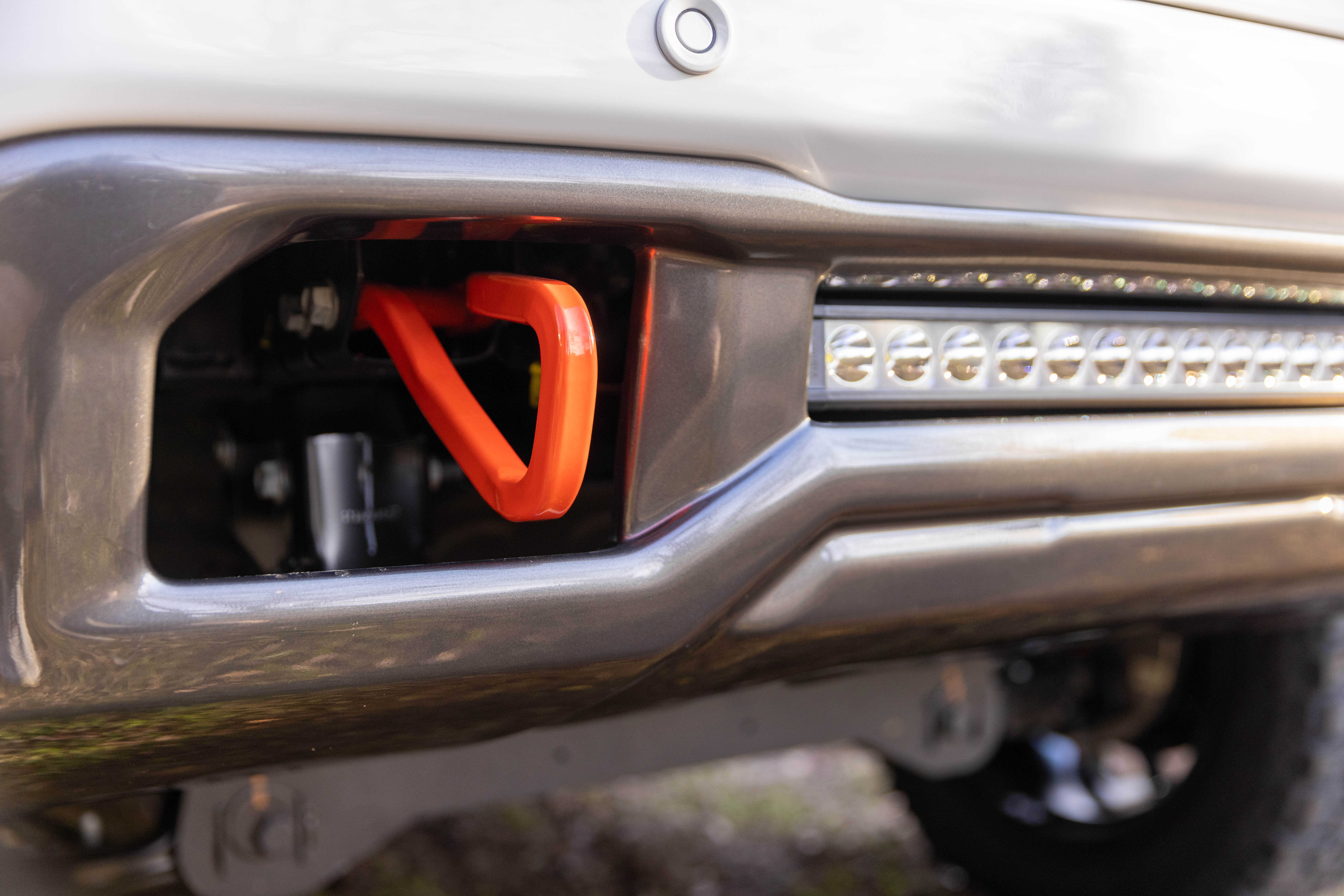 accented orange tow hooks and integrated led light bar on harley-davidson truck gmc sierra 1500