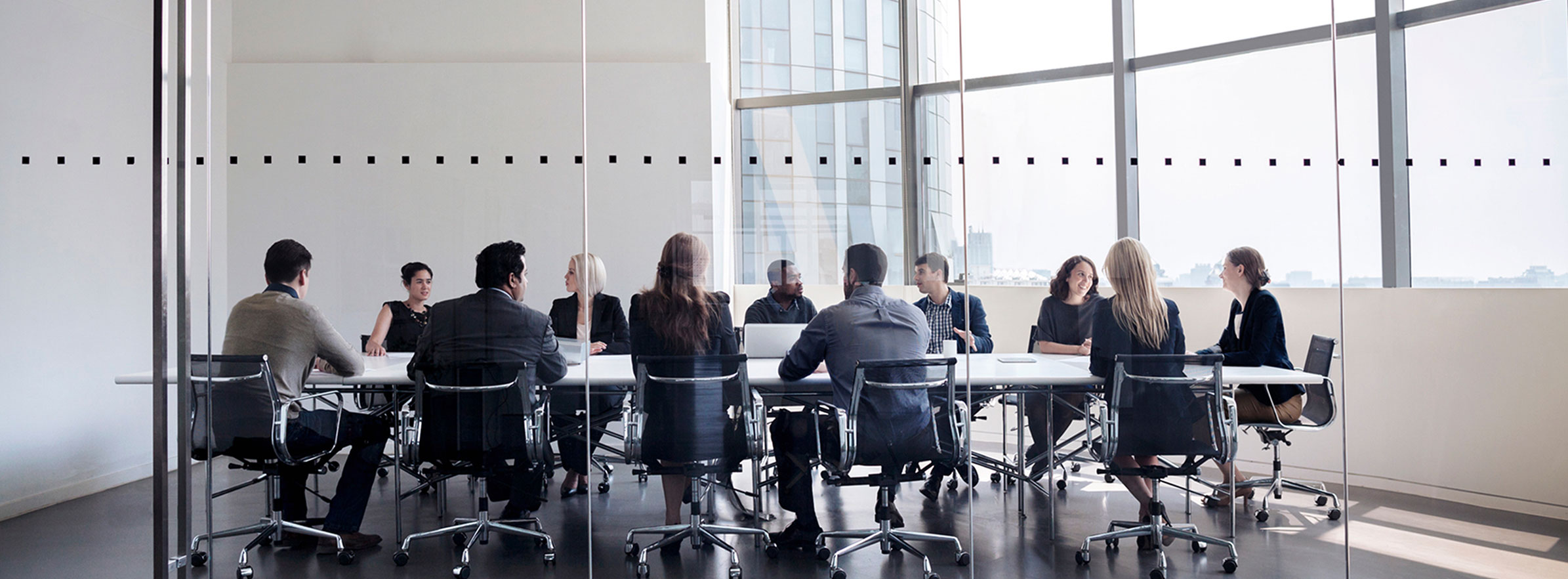 Boardroom with business men and women sitting at the table