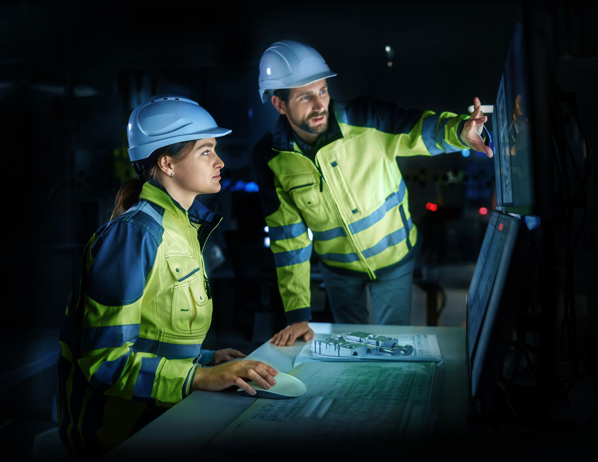 Engineers discussing plans on the monitor