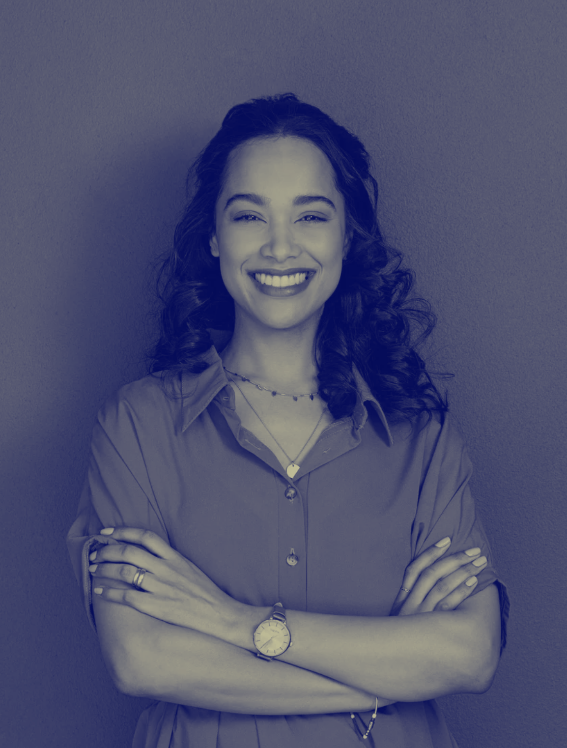 Portrait of a young latin woman with pleasant smile and crossed arms isolated on grey wall with copy space. Cheerful hispanic woman on grey background with copy space. Beautiful girl with folded arms looking at camera against grey wall.