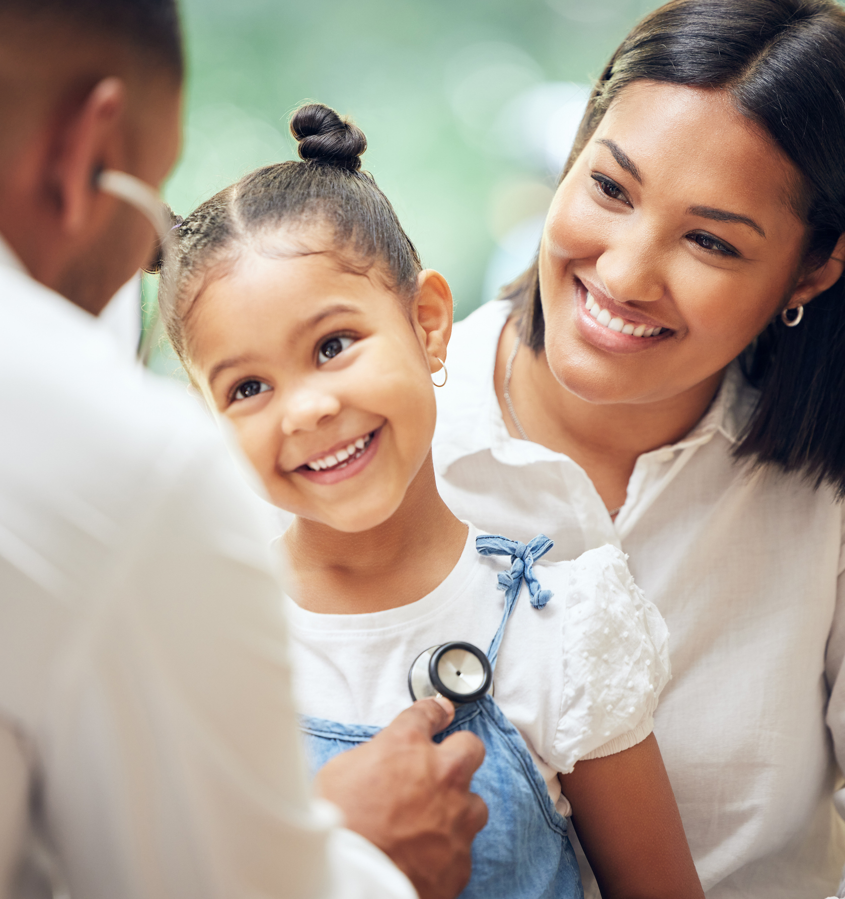 Male doctor examining happy little girl by stethoscope. 
